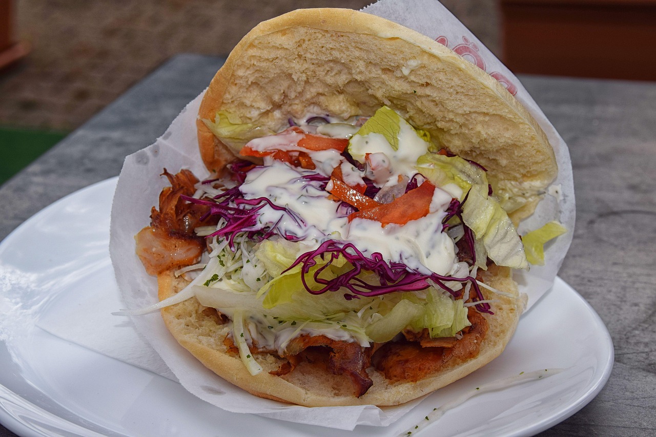 Ein klassischer Döner Kebab im Fladenbrot mit Fleisch und knackigem Salat serviert.