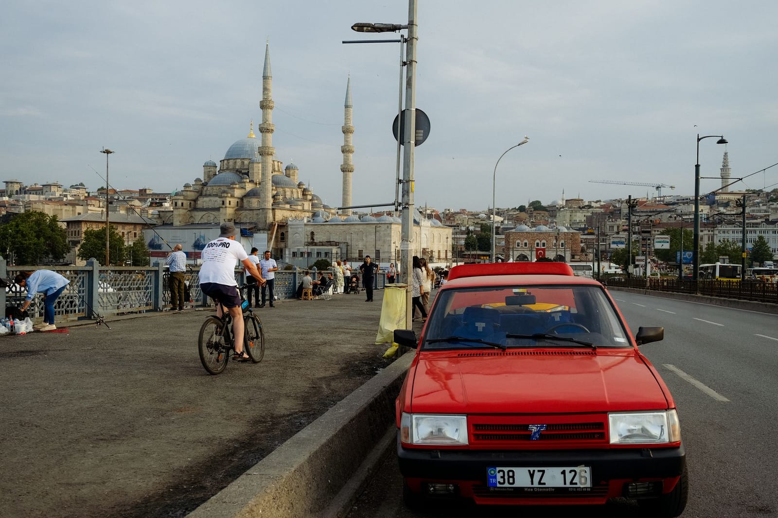 Ein Radfahrer fährt über die belebte Galatabrücke mit Blick auf eine Moschee.