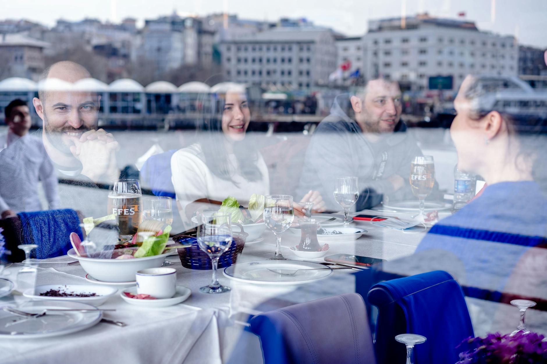 Gäste trinken Efes Bier in einem Restaurant mit Blick auf die Stadt Istanbul.