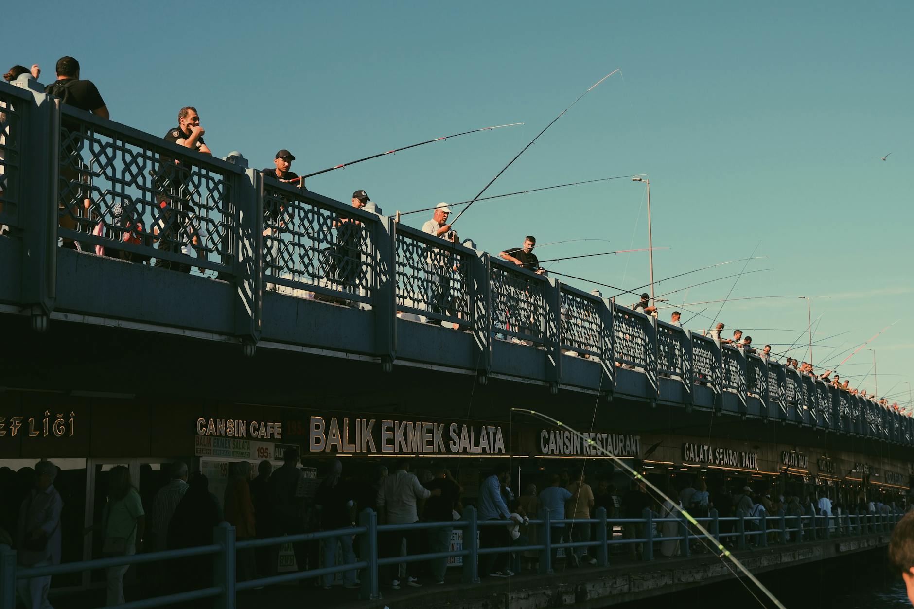Die Galata-Brücke am Goldenen Horn mit Fischern und traditionellen Balık-Ekmek-Ständen darunter.