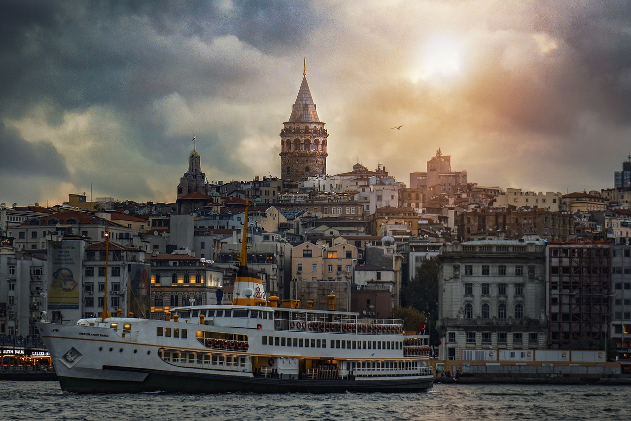 Malerischer Sonnenuntergang über dem Galata-Turm mit einem vorbeifahrenden Schiff im Vordergrund.