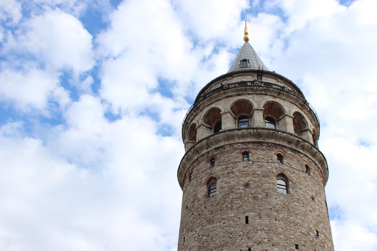 Nahaufnahme der Spitze des Galata-Turms vor einem leicht bewölkten blauen Himmel.