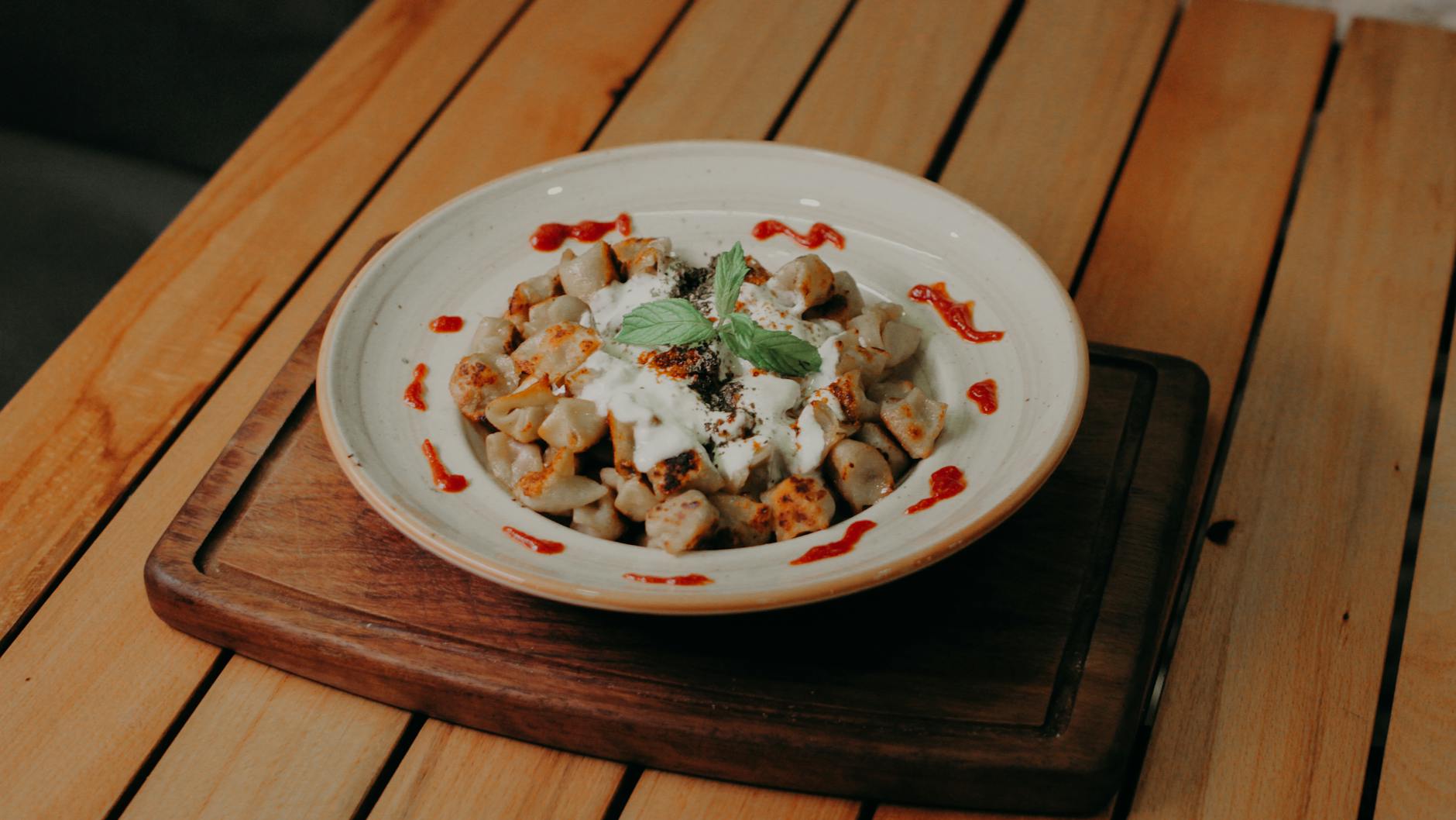 Ein Teller mit handgemachten türkischen Mantı serviert mit Joghurt und Paprikabutter.