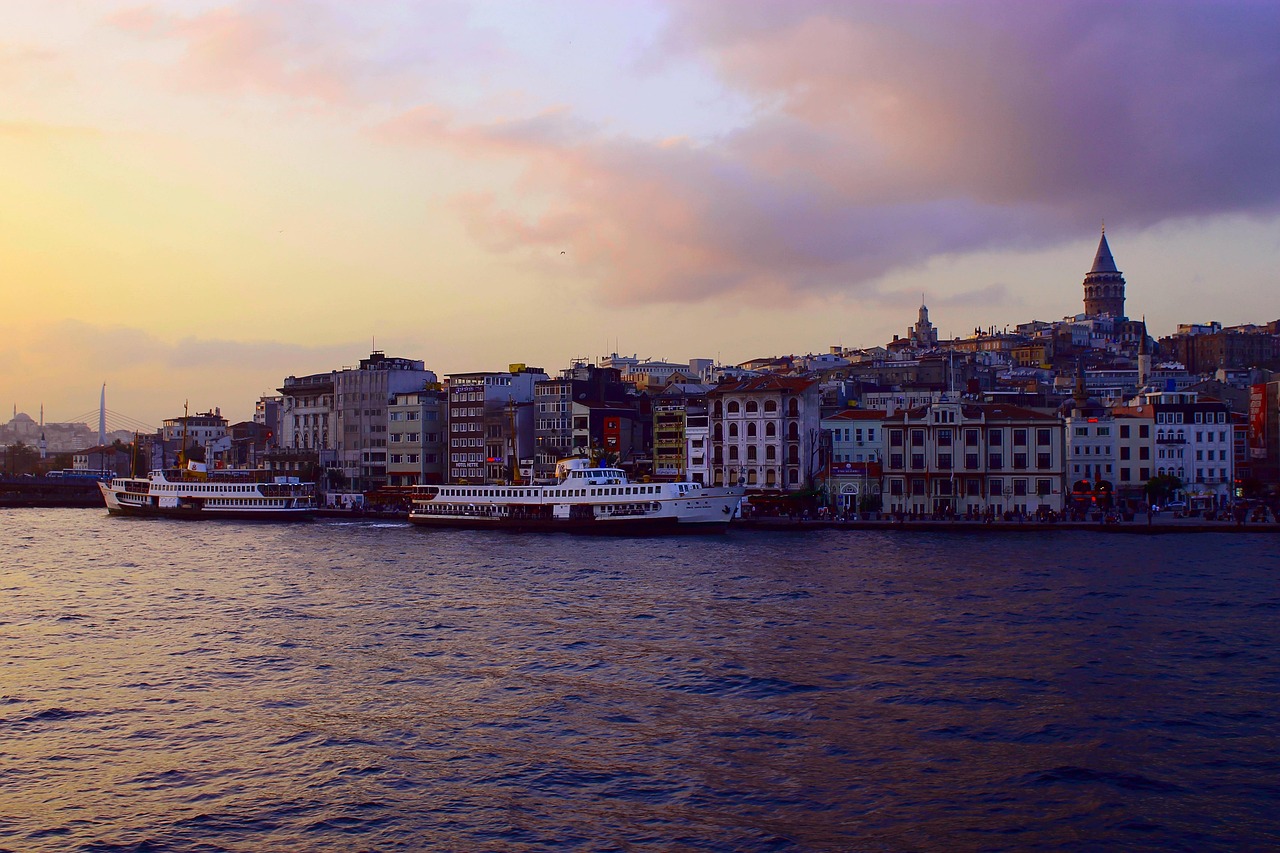 Panorama von Istanbul mit dem Galata-Turm und Schiffen auf dem Goldenen Horn bei Dämmerung.