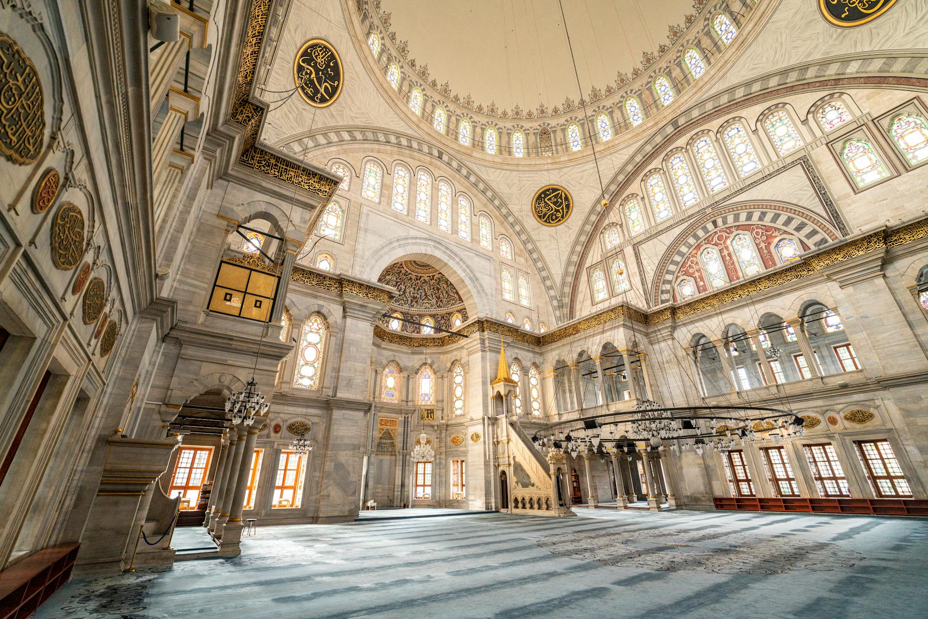 Prachtvoller Innenraum der Nuruosmaniye Moschee mit Marmorwänden und vielen bunten Glasfenstern.