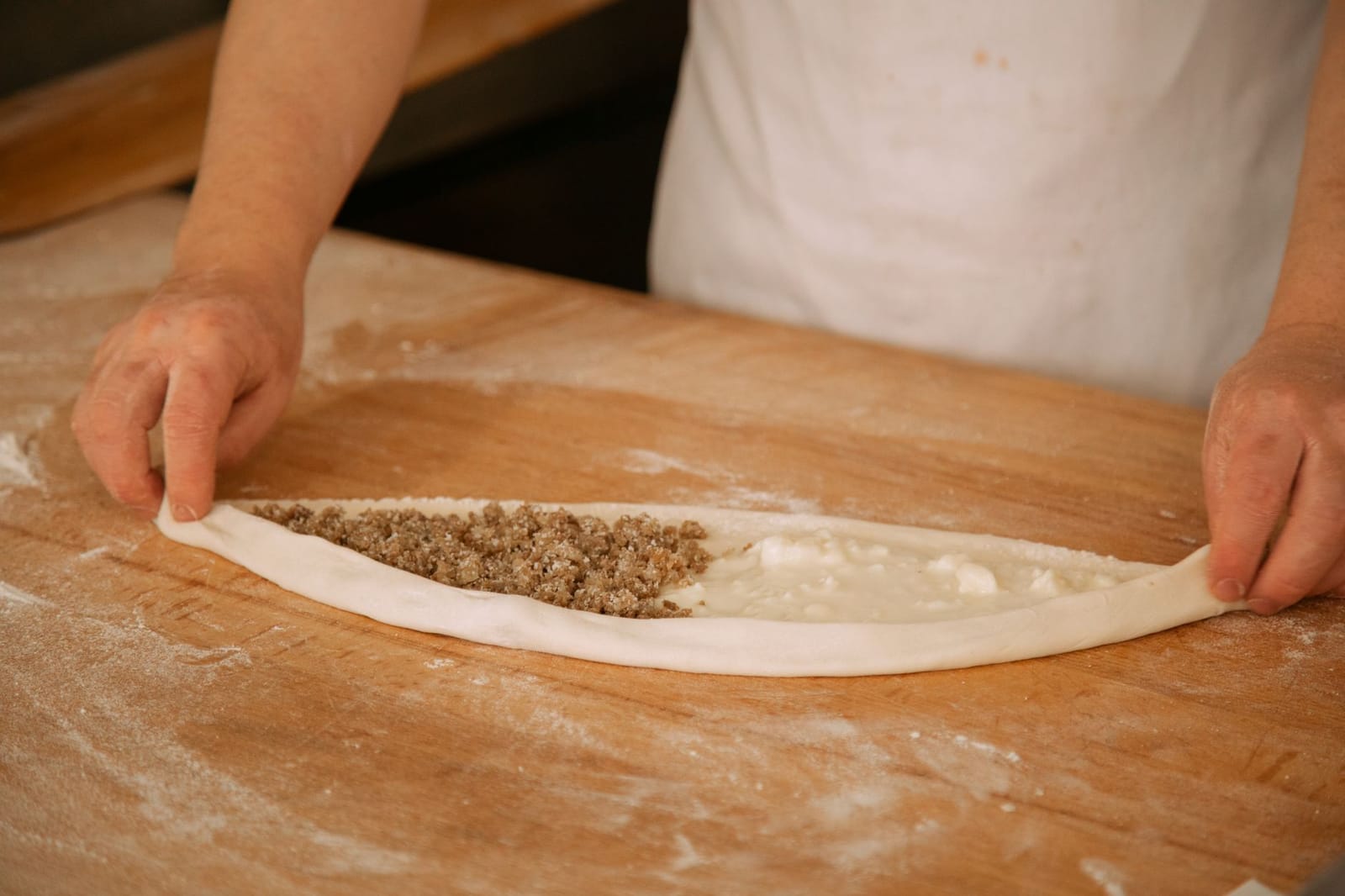 Ein Bäcker formt den traditionellen Pide-Teig mit herzhafter Fleisch- und Käsefüllung.