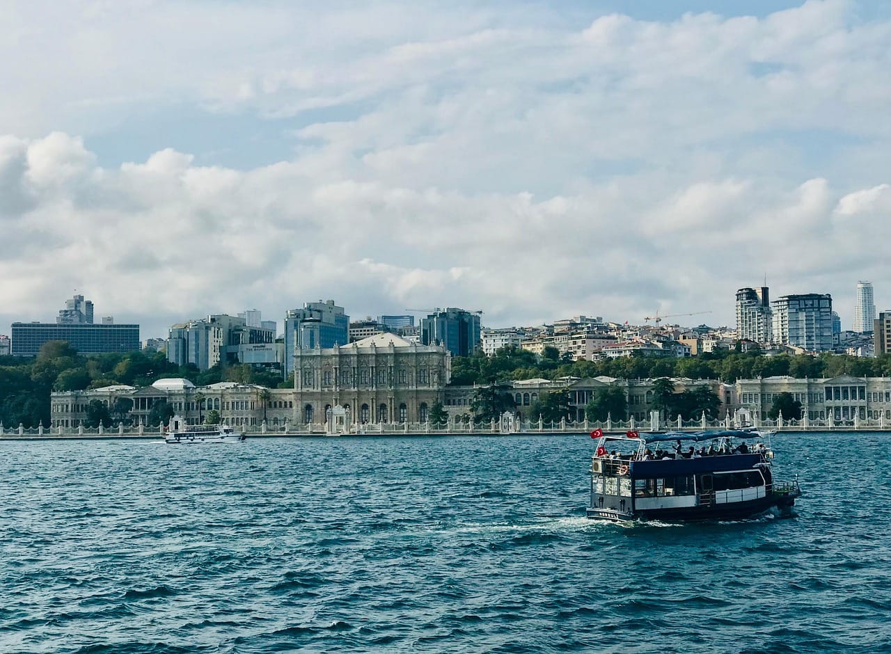 Ein Rundfahrtboot fährt auf dem Bosporus am Ufer des Dolmabahçe-Palastes vorbei.