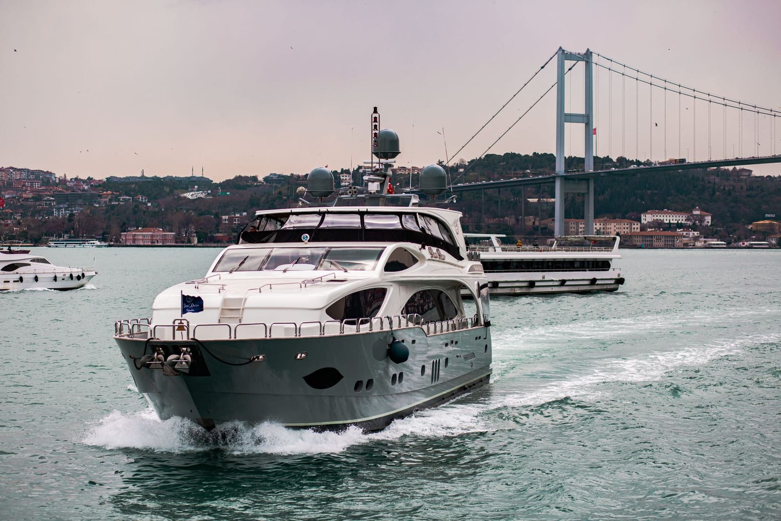 Eine private Motoryacht fährt auf dem Bosporus vor der großen Hängebrücke.