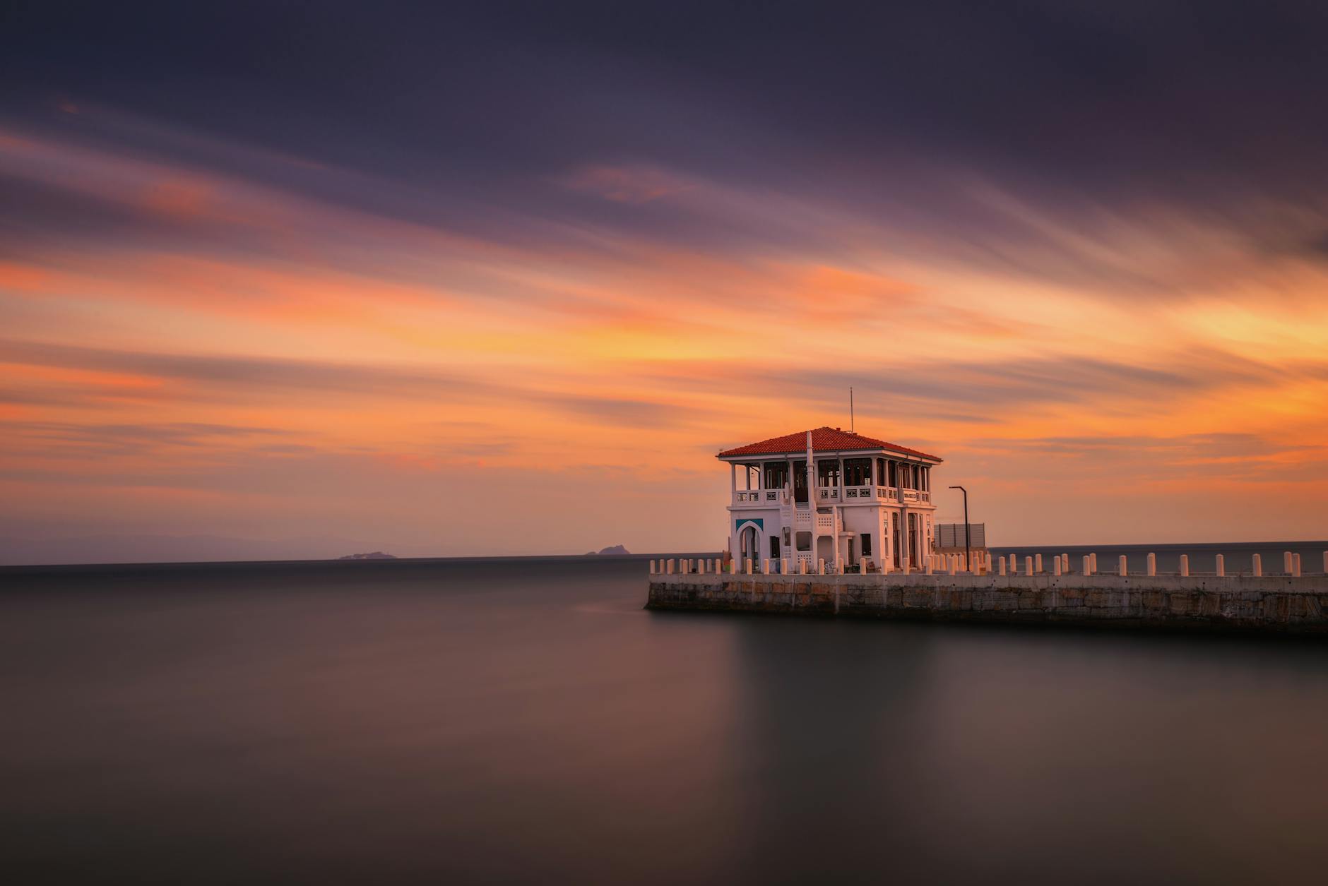 Ein spektakulärer farbenfroher Sonnenuntergang bildet die Kulisse für die historische Anlegestelle in Moda.