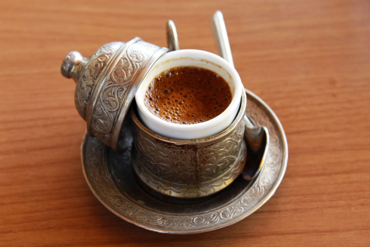 Frisch gebrühter türkischer Mokka in einer verzierten silbernen Tasse serviert.
