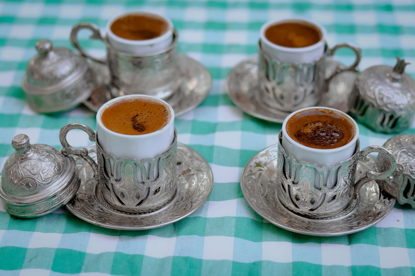 Türkischer Kaffee serviert in traditionellen silbernen Haltern mit Deckel.