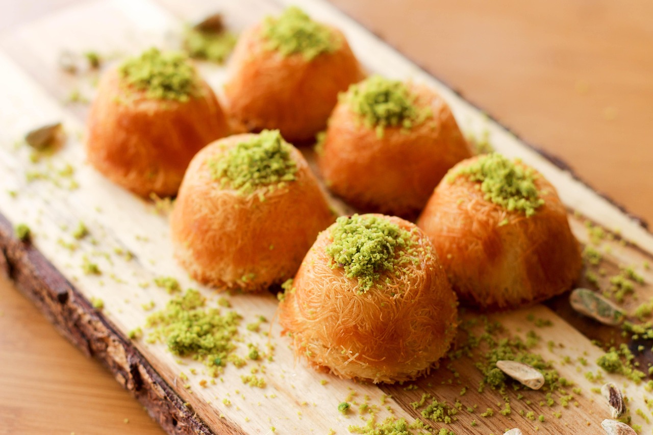 Kleine Türme aus feinem Kadayıf-Teig sind mit gehackten Pistazien bestreut.