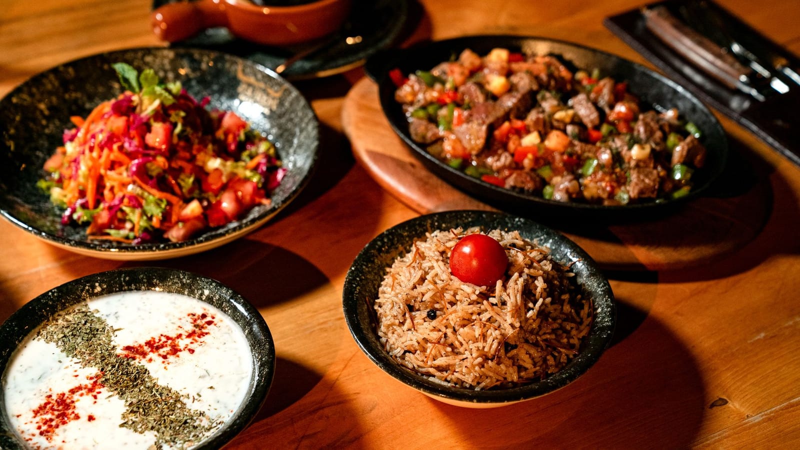 Traditionelles türkisches Menü mit Reis, Fleischgericht und Meze in einem Lokal.