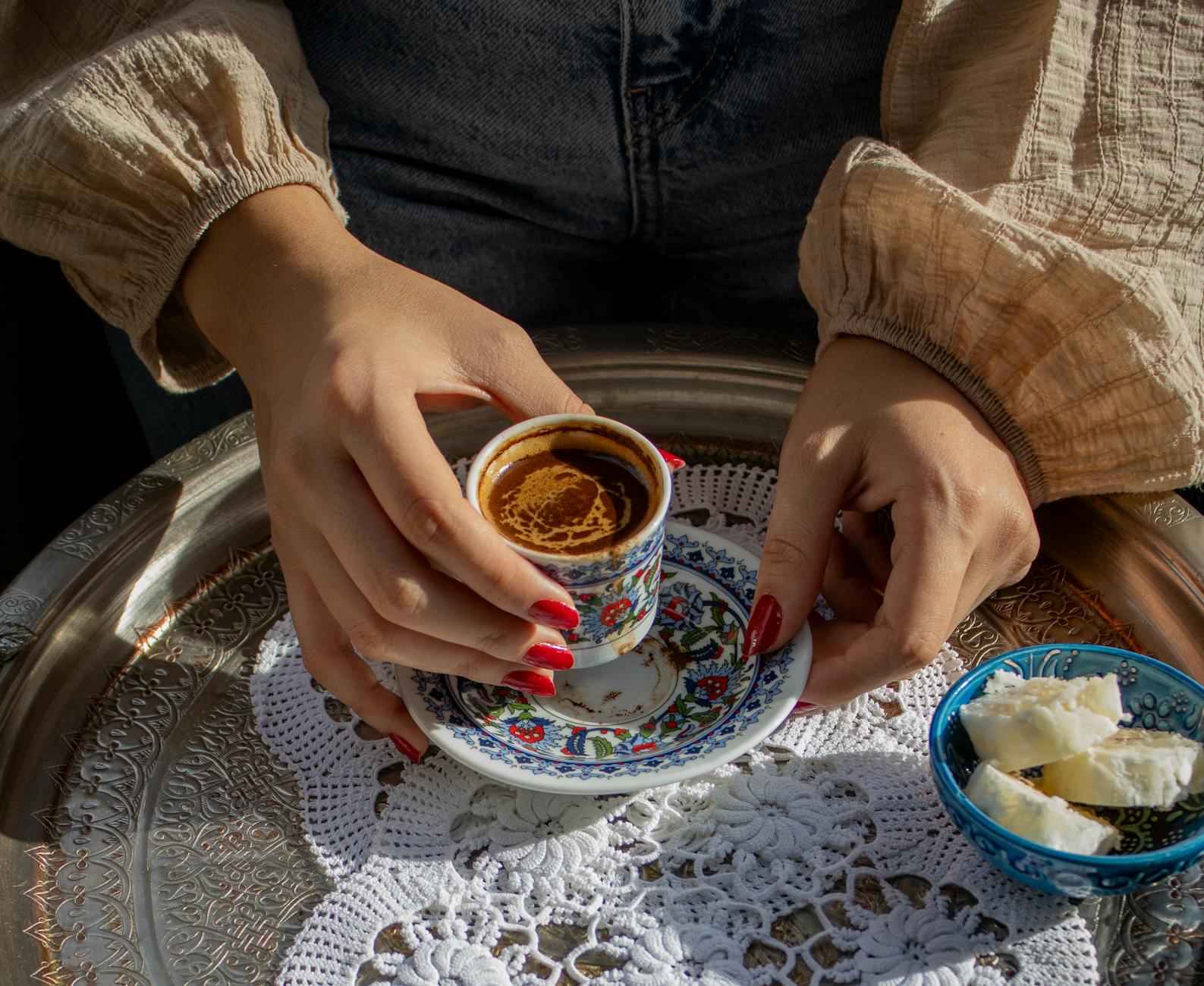 Traditioneller türkischer Kaffee serviert auf einem verzierten Silbertablett mit kleinen Lokum-Stücken.