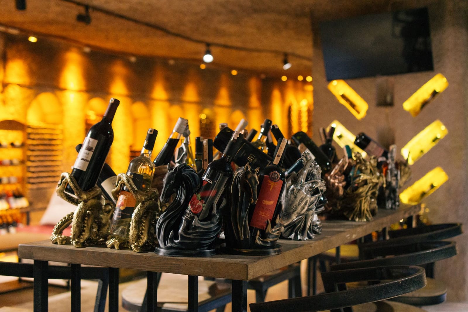 Auswahl türkischer Weinflaschen auf einem Holztisch in einer Weinbar.