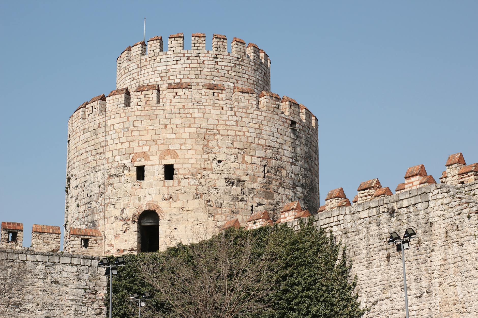 Ein massiver runder Steinturm der Festung Yedikule vor blauem Himmel in Istanbul.